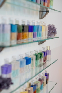 Aura-Soma® Flaschen mit farbigen Equilibrium-Essenzen und Kristall im Apothekerschrank der Naturheilpraxis Antje Hansen in Forchheim