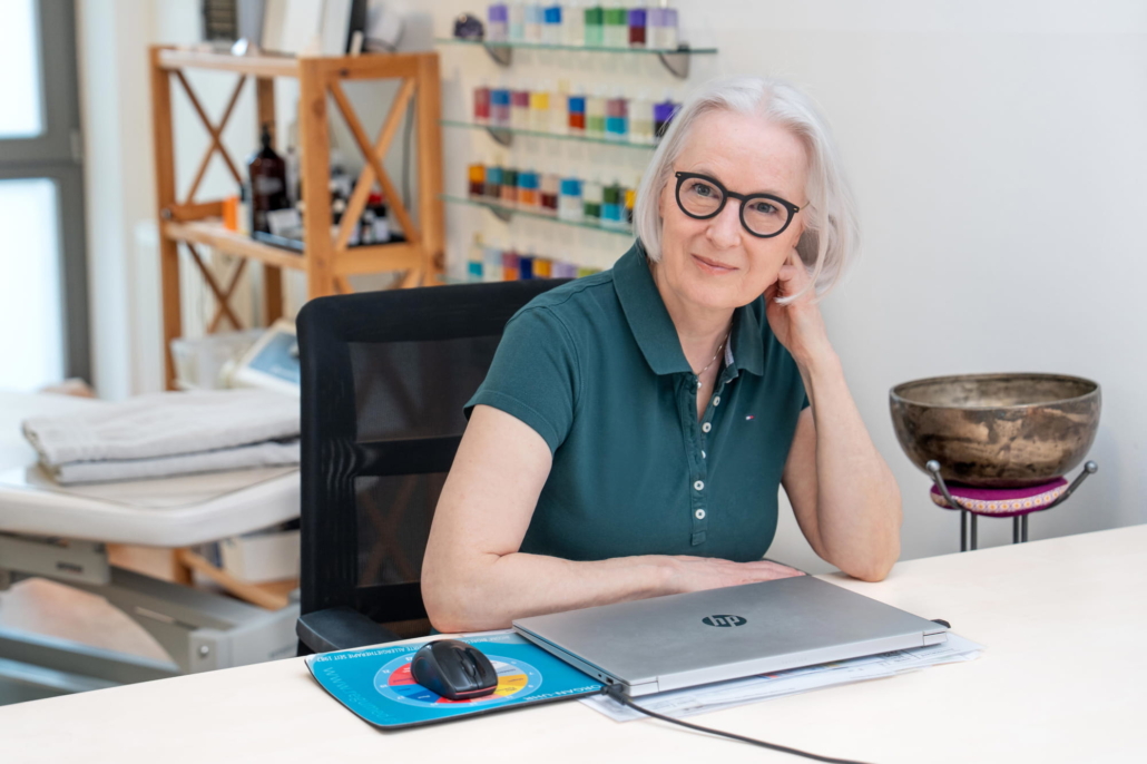 Antje Hansen in ihrer Naturheilpraxis in Forchheim am Schreibtisch mit Laptop und Klangschale – Expertin für Kinesiologie und Brain Gym®
